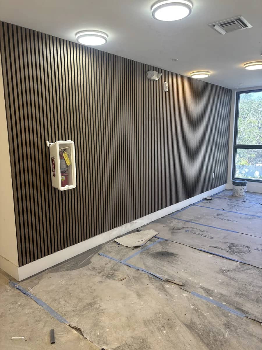 Aventura Quattro, photographed 23 February 2026: the ground-floor corridor with its slatted feature wall installed and floor protection still down.